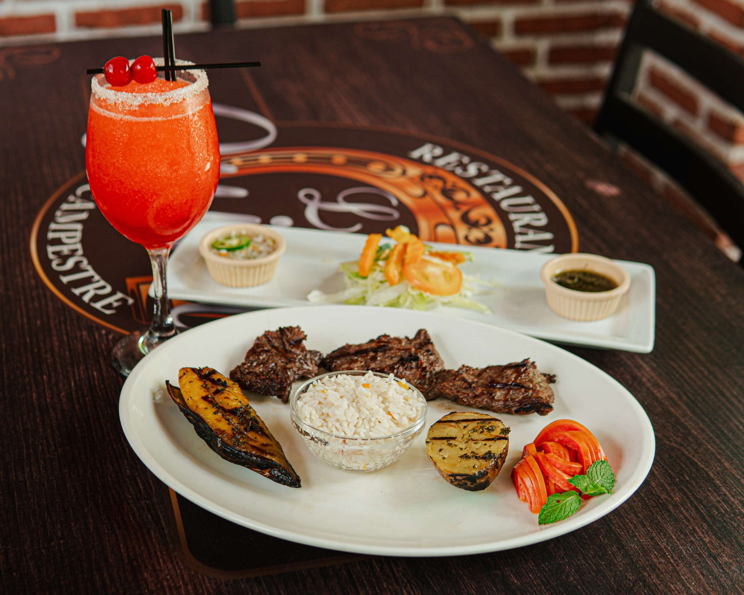 Grilled steak with rice and roasted vegetables on a white plate