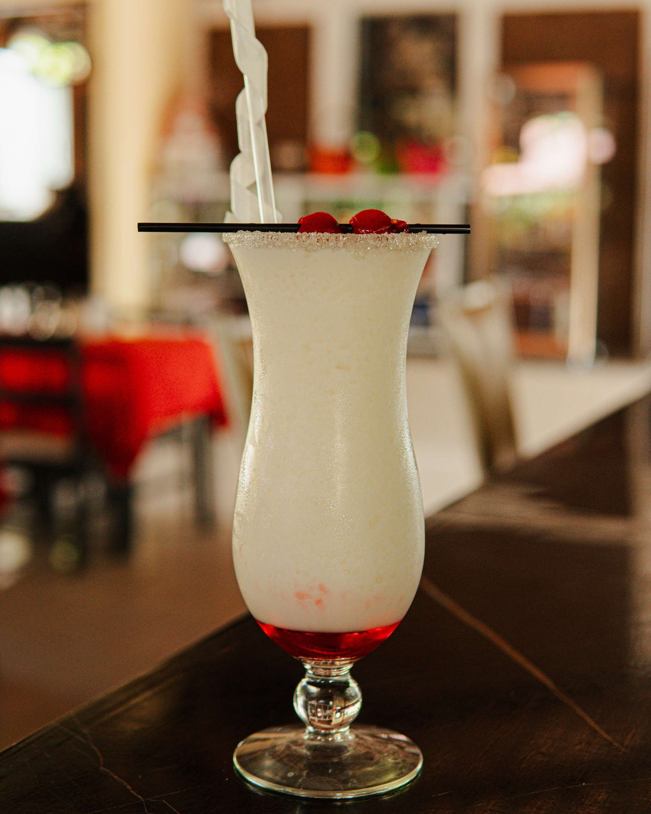 Piña colada con cerezas en copa alta
