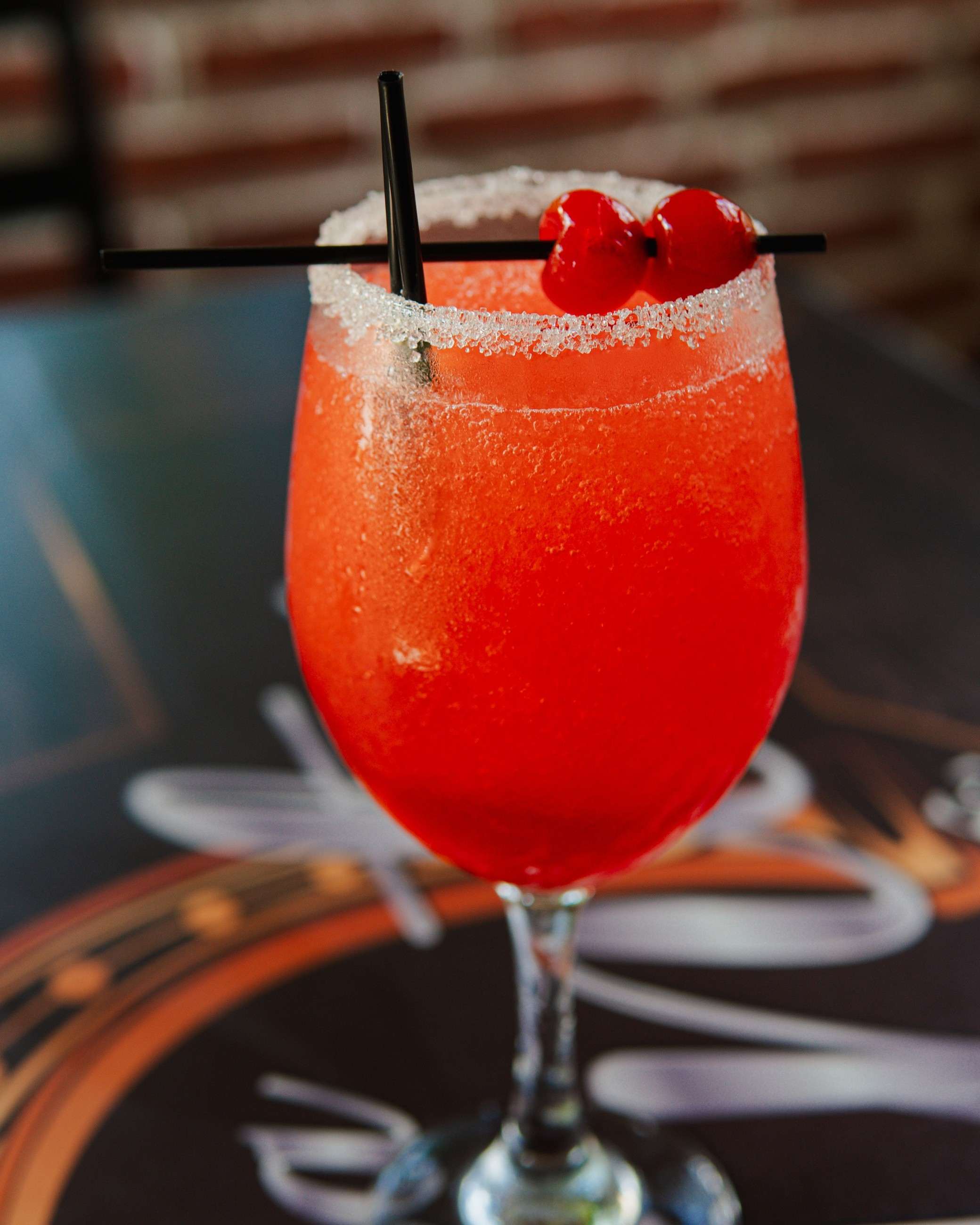 Red sugar-rimmed cocktail with cherries