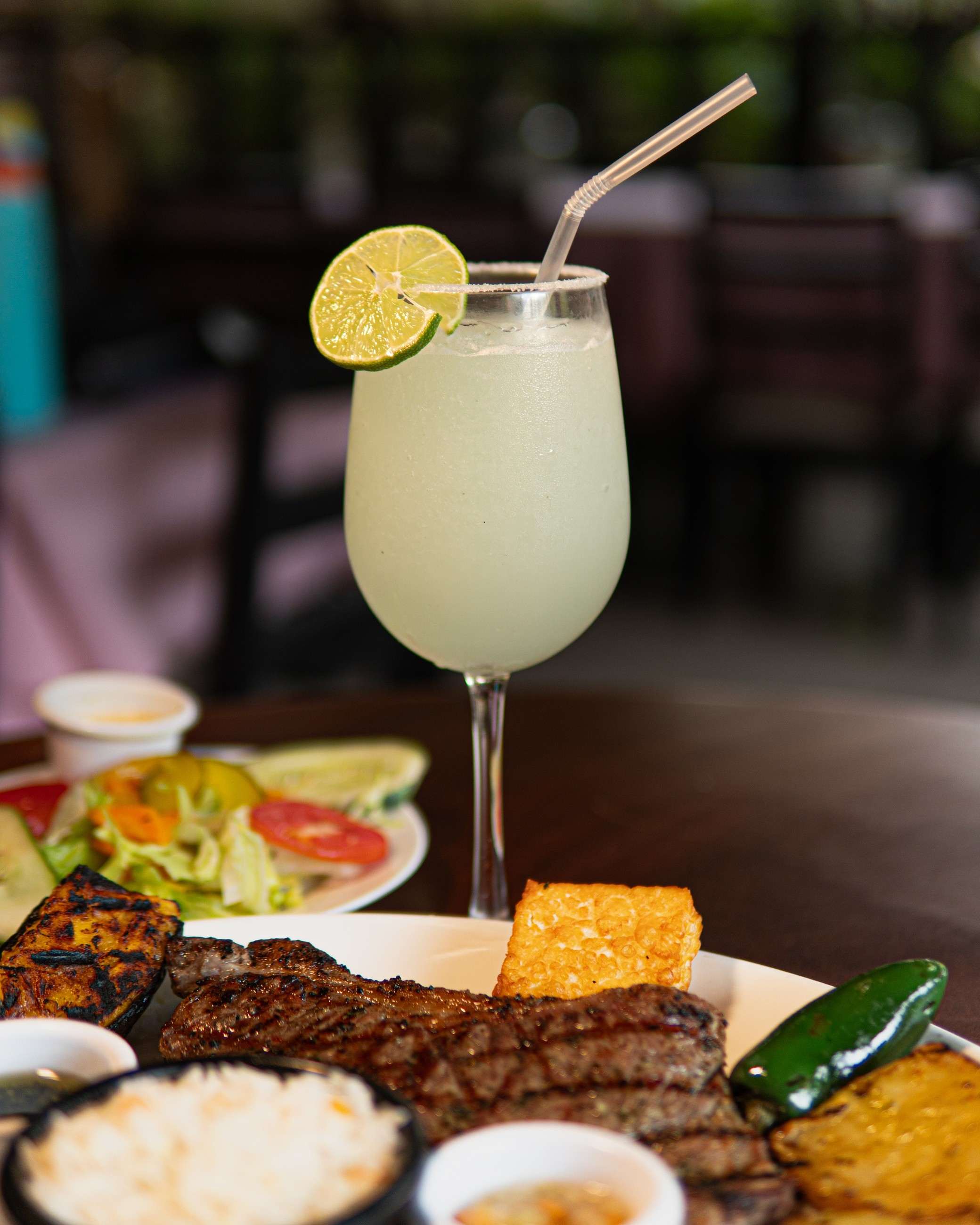 Corte a la parrilla con papas y una limonada con rodaja de limón