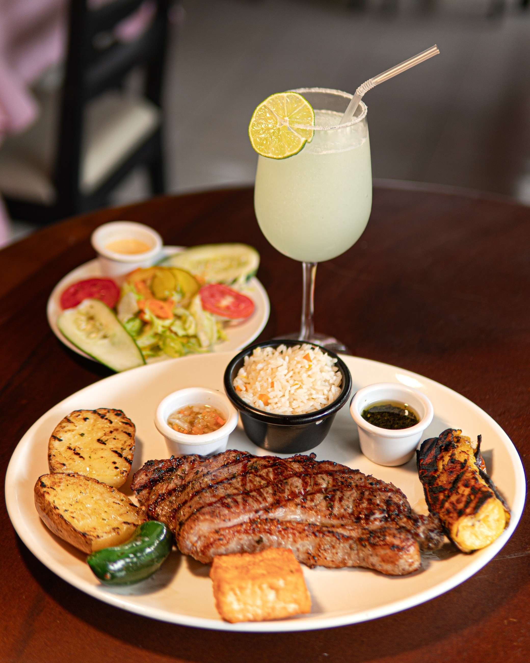 Corte de res a la parrilla con papas, arroz y una limonada con rodaja de limón