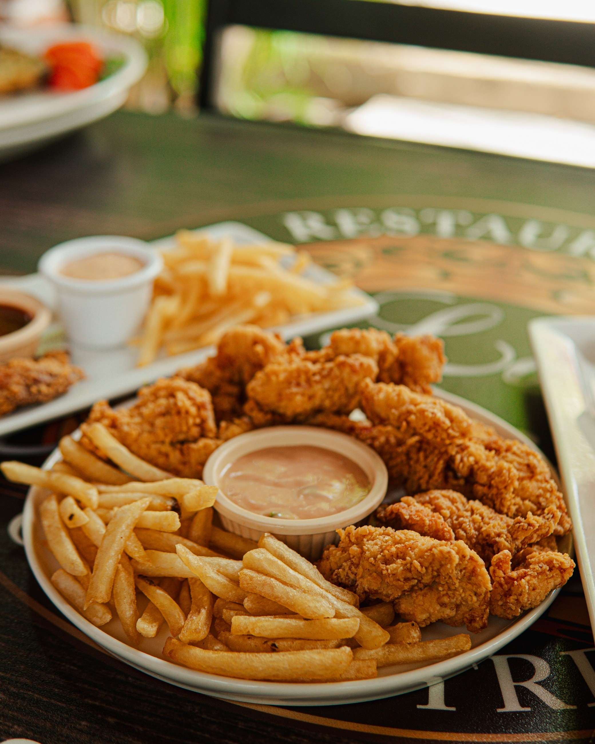Dedos de pollo empanizados con papas fritas y salsa